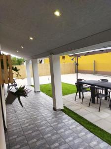 a patio with a table and chairs and an umbrella at Csengő Vendégház in Kiskőrös