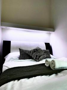 a bed with black and white pillows on it at Fakanalas Fogadó in Pásztó