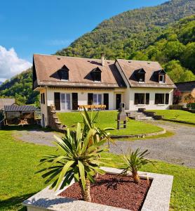una casa con una palmera delante de ella en Grande villa avec jardin privatif - Bagnères de Luchon en Juzet-de-Luchon