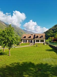 una casa con un árbol en medio de un campo en Grande villa avec jardin privatif - Bagnères de Luchon en Juzet-de-Luchon