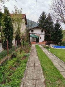 a house with a pathway leading to a yard at Relax house in Visoko