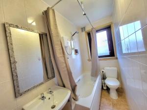a bathroom with a tub and a toilet and a sink at 3 Bedroom Aprtmt at Sensational Stay Serviced Accommodation Aberdeen- Froghall Avenue in Aberdeen +12 photos