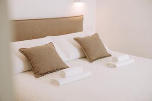 a white bed with three pillows on it at Dimora Anderì in Polignano a Mare