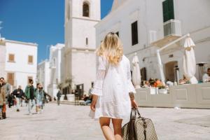 a woman in a white dress walking down a street at Dimora Anderì in Polignano a Mare