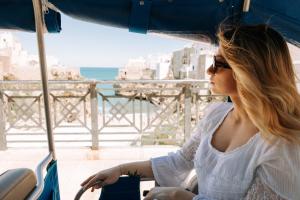 a woman sitting on a boat looking out at the ocean at Dimora Anderì in Polignano a Mare