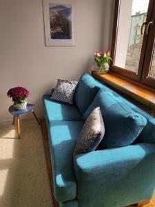 a blue couch in a living room with a window at JLS Apartament z parkingiem przy plaży in Gdańsk