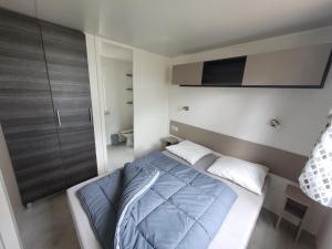 a bedroom with a bed and a tv on the wall at mobil home - camping les dunes de Contis in Saint-Julien-en-Born