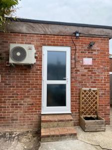 a brick building with a window and a fan at Private Cosy 1Bd in town in Fareham