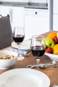 two glasses of wine on a wooden table with fruit at Golden Rose Suit pension in Kaş