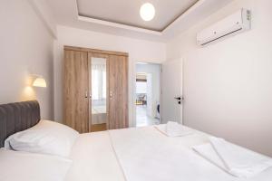 a bedroom with a white bed and a door at Golden Rose Suit pension in Kaş