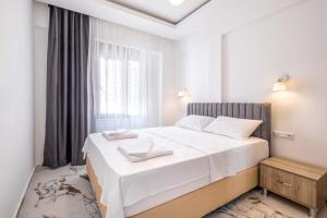 a white bedroom with a large bed and a window at Golden Rose Suit pension in Kaş