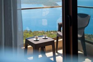 a table and chairs on a balcony with a view of the ocean at Golden Rose Suit pension in Kaş