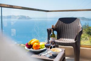 a table with a plate of fruit and a bottle of wine at Golden Rose Suit pension in Kaş