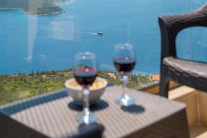 two glasses of wine on a table with a view of the ocean at Golden Rose Suit pension in Kaş