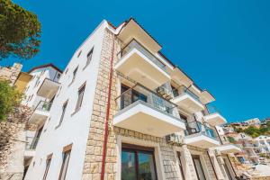 a tall white building with a balcony on it at Golden Rose Suit pension in Kaş