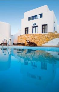 a house with a swimming pool in front of a building at Pegados Villas in Chora Folegandros