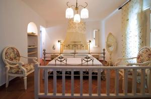 ホラ・フォレガンドロスにあるPegados Villasのベッドルーム1室(大型ベッド1台、椅子2脚付)