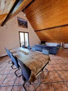 una sala da pranzo con un grande tavolo in legno e sedie blu di Grande villa avec jardin privatif - Bagnères de Luchon a Juzet-de-Luchon