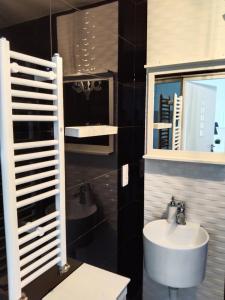 a bathroom with a sink and a toilet and a mirror at Willa La mer-Balia z jacuzzi, sauna ,klimatyzacja ,rowery in Ustka +151 photos
