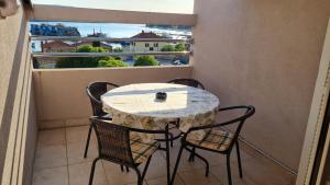 a table and chairs on a balcony with a window at Apartman Bella in Cres