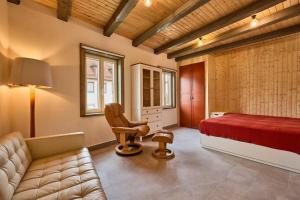 ein Schlafzimmer mit einem Bett, einem Stuhl und einem Sofa in der Unterkunft Rote Wohnung - Goldenes-Häusle in Sulzbach an der Murr