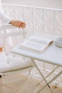 a person sitting on a chair with a book on a table at Dimora Anderì in Polignano a Mare