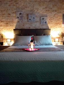 a bottle of wine and two glasses on a bed at Harmony in Lávrion