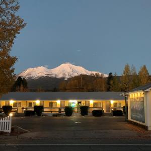 a building with a snow covered mountain in the background at Cold Creek Inn in Mount Shasta