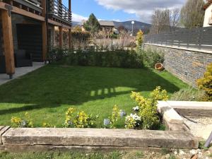 a garden with a lawn with flowers and a building at Maison à Bourg Madame in Bourg-Madame