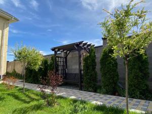 a garden with a wooden bench in a backyard at Aikol in Bishkek