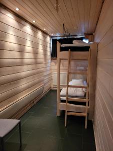 a room with a bunk bed in a wooden cabin at Chalet Päämaja Rovaniemi in Rovaniemi