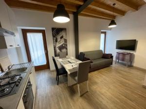 a kitchen and living room with a table and a couch at DIVINA SAN ZENO in Verona