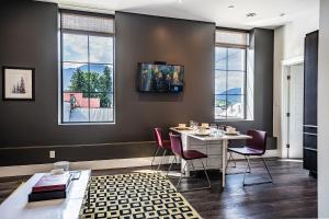 a dining room with a table and chairs and windows at In the Heart of it All by Revelstoke Vacations in Revelstoke