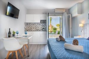 a bedroom with a bed and a table and a kitchen at Nondas Apartments in Lassi