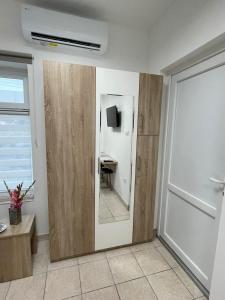 a room with a door with a mirror and a desk at Apartman Dunav in Kladovo