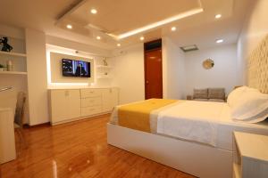 a bedroom with a bed and a tv on a wall at Mercé Hotel in Tacna