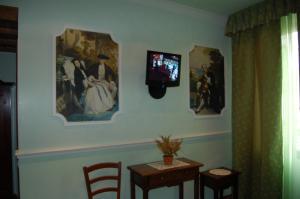 a room with a tv on a wall with a table and chairs at Sul Bacino in Massa Lombarda