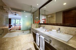 a bathroom with two sinks and a tub and a mirror at Grand Palladium Imbassaí Resort & Spa - All Inclusive in Imbassai