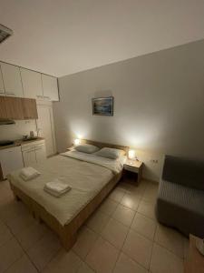 a small bedroom with a bed and a couch at Apartman Dunav in Kladovo