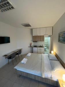 a bedroom with a bed and a desk and a kitchen at Apartman Dunav in Kladovo