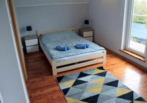 um quarto com uma cama com duas almofadas azuis em Dom Wakacyjny Sarbsk Pomerania em Sarbsk