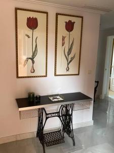a table in a room with two pictures on the wall at Marbella Cabopino golf and beach only Adults in Marbella