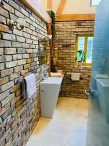 ein Badezimmer mit einer Backsteinwand und einem Waschbecken in der Unterkunft Sonnenhügel in Neu Karin