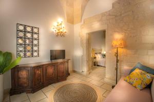 een woonkamer met een bank en een televisie bij FORLEO Historic Apartments - TREB Collection in Lecce