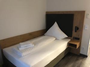 Una cama con dos almohadas blancas encima. en Waldschlößl, en Bruckmühl