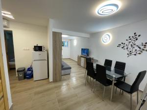 salon ze stołem, krzesłami i lodówką w obiekcie Fesztivál Balaton parti Apartman w Balatonföldvárze