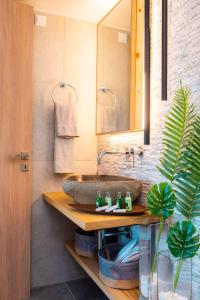 La salle de bains est pourvue d'un lavabo et d'un miroir. dans l'établissement Sunset Coast House - STONE, à Vathi