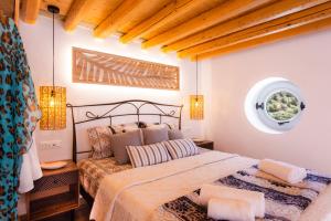 1 dormitorio con cama y ventana en Sunset Coast House - STONE, en Vathi