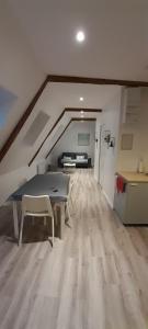 an attic room with a table and a couch at Appartement dans maison de 1789 au centre de Vitré in Vitré