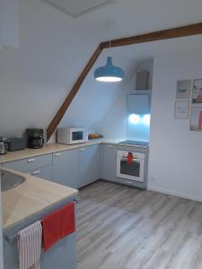 a kitchen with white cabinets and a stove top oven at Appartement dans maison de 1789 au centre de Vitré in Vitré +8 photos